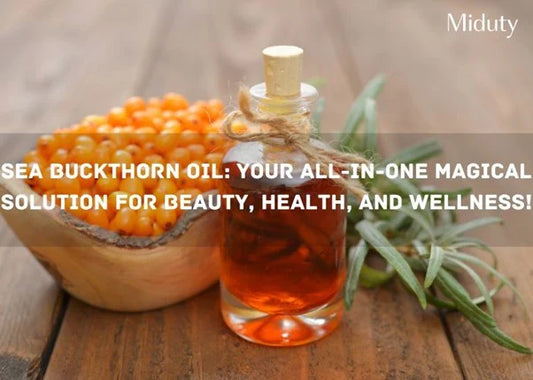 Glass bottle of sea buckthorn oil with orange berries in a bowl, on a wooden surface.