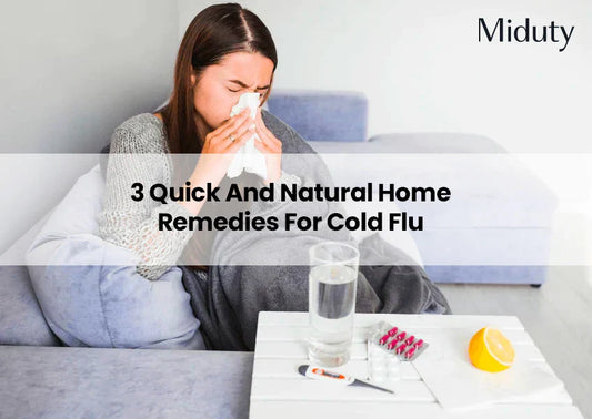 Person sitting on a couch, blowing their nose, with a glass of water and remedies on a table