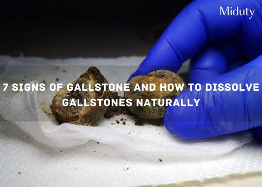 Two gallstones being held in a gloved hand on a tissue surface.