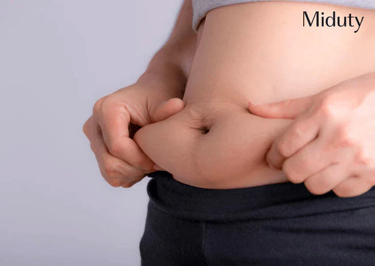 Person grabbing abdominal fat near waist