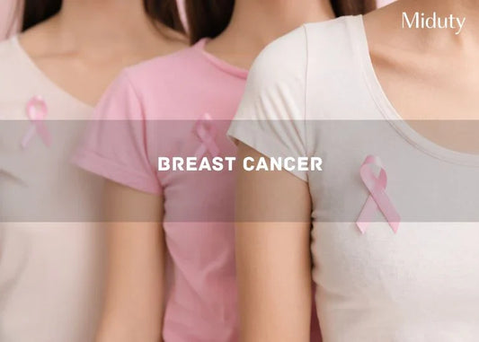 Three women wearing pink shirts with pink ribbons for breast cancer awareness