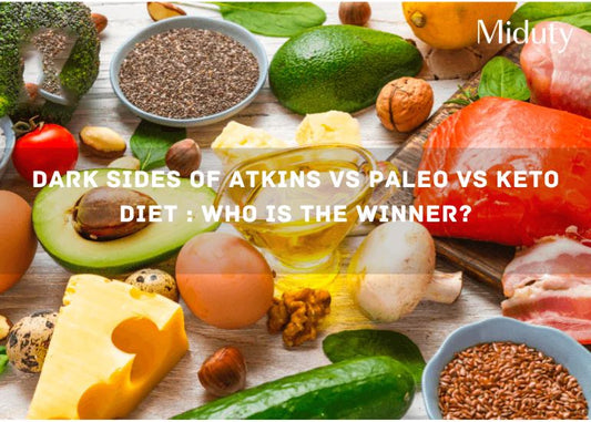 Assorted healthy foods including vegetables, nuts, cheese, and meat on a wooden surface.