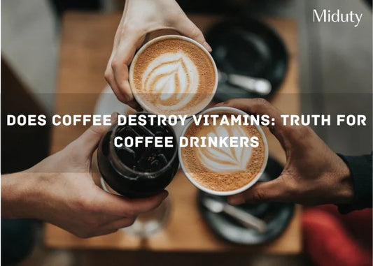 Two hands holding coffee cups and a cold beverage on a table