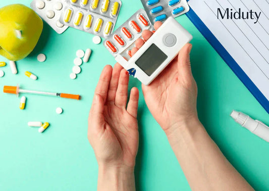 Hands holding a glucose meter surrounded by vitamin supplements and an apple