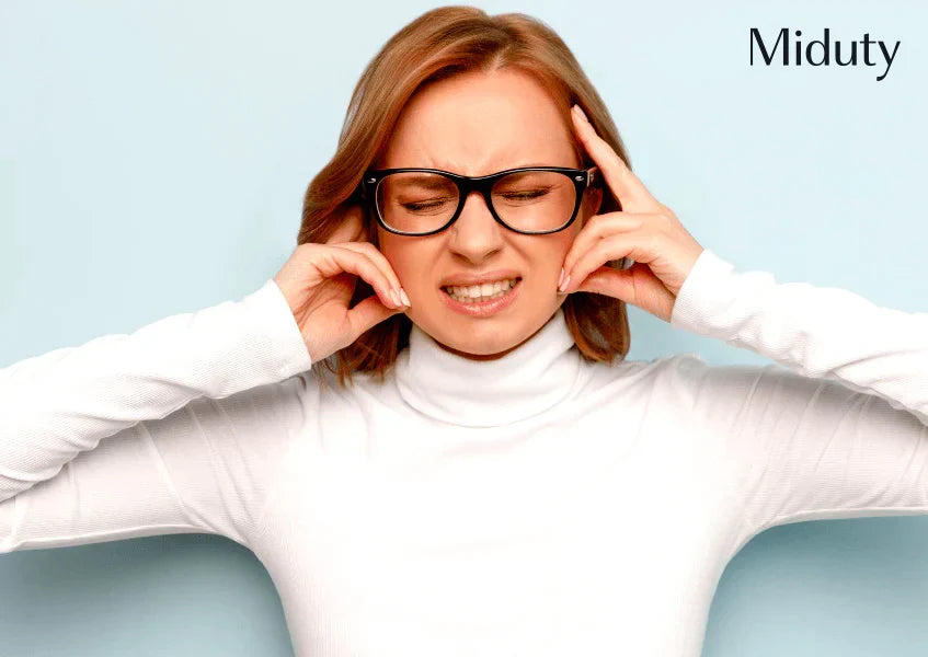 Person in a white turtleneck holding their head, showing discomfort, against a light blue background.