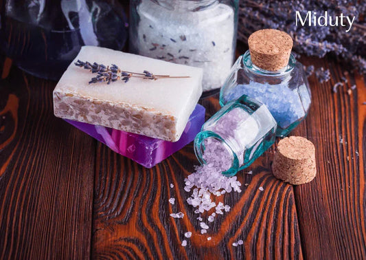 Colorful soaps and jars filled with bath salts on a wooden surface