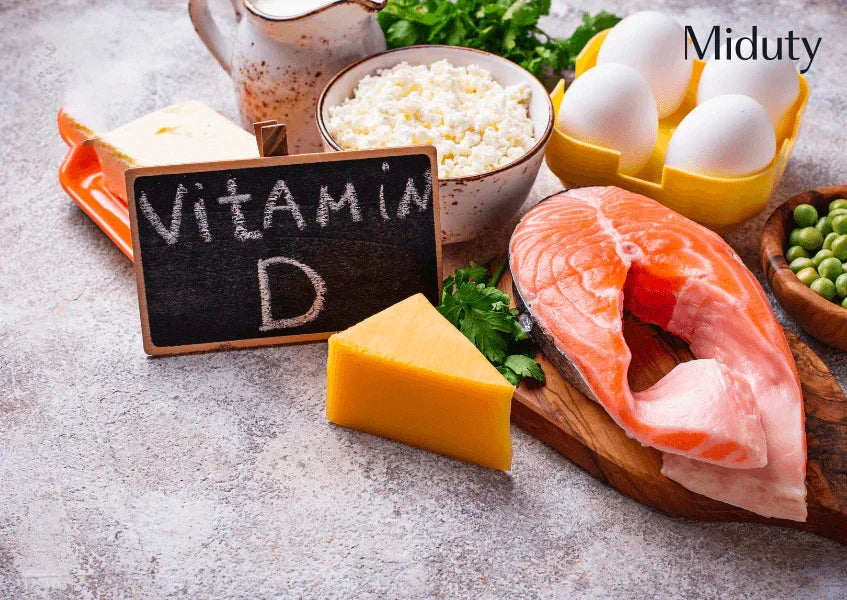 Assorted foods rich in vitamin D including salmon, eggs, cheese, and greens with a chalkboard label.