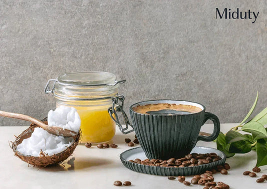 A cup of coffee, a jar of yellow substance, and a bowl of coconut with coffee beans scattered around.