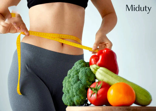 Person measuring waist with tape, surrounded by fresh vegetables