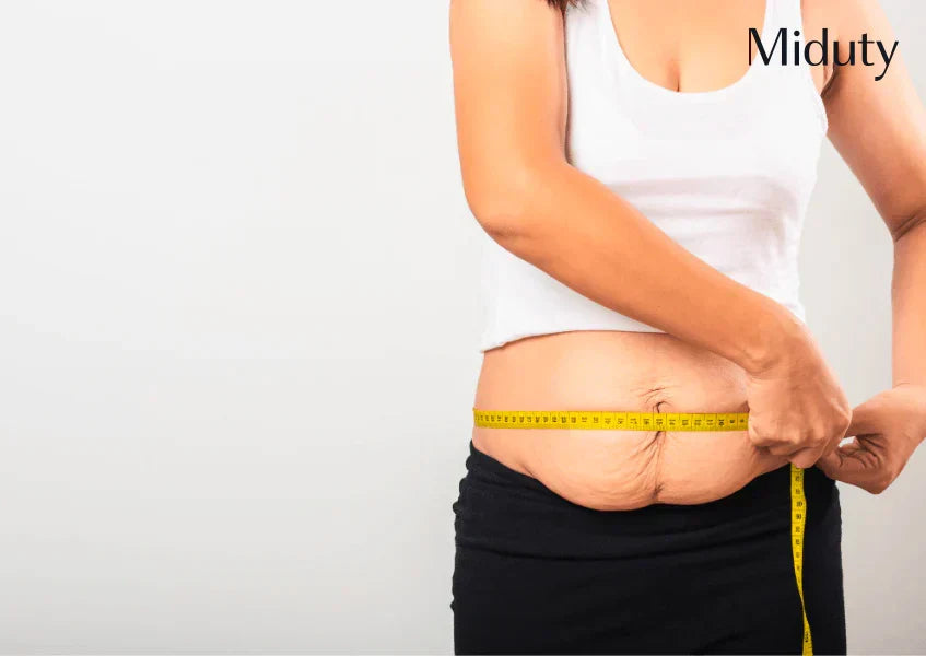 Woman measuring her waist with a tape measure after pregnancy