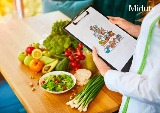 Person holding a clipboard with a diet chart, surrounded by fresh fruits and vegetables.