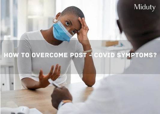 Person wearing a mask discussing health concerns with a doctor in a clinic