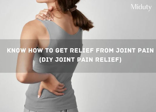 Person holding their lower back in discomfort, wearing a gray tank top.