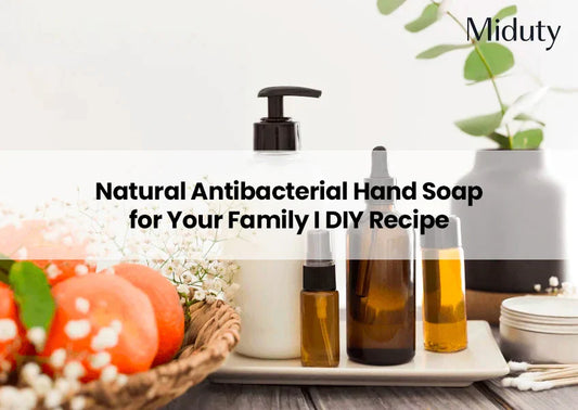 Bottles of natural hand soap and essential oils on a table with decorative elements.