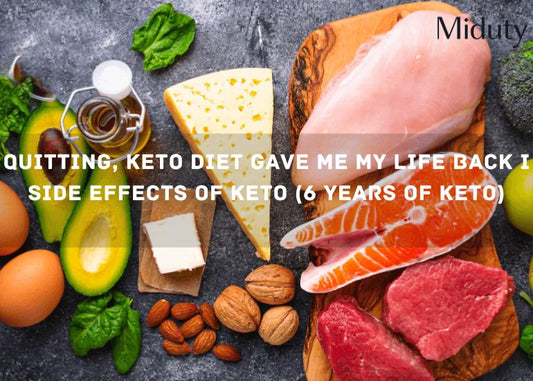 Assorted fresh keto-friendly foods including avocado, meat, eggs, cheese, and nuts on a wooden surface.