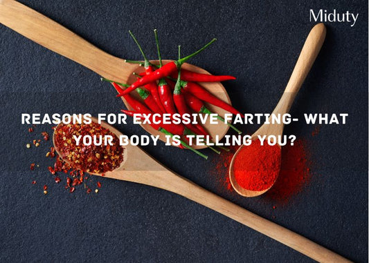 Spoons with red chili peppers and ground chili on a dark surface