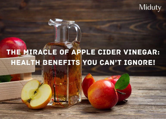 Jug of apple cider vinegar with fresh apples on a wooden surface