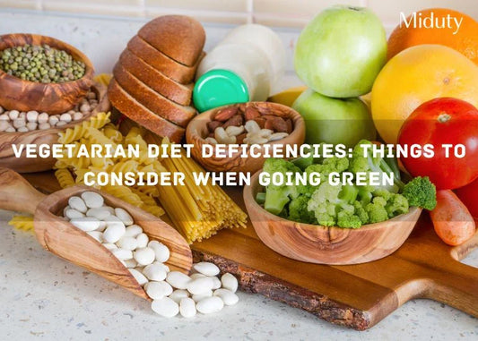 Assorted vegetarian foods including beans, grains, fruits, and vegetables on a wooden table.