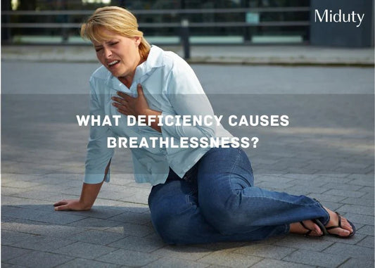 Woman crouching on the ground, appearing distressed and clutching her chest.